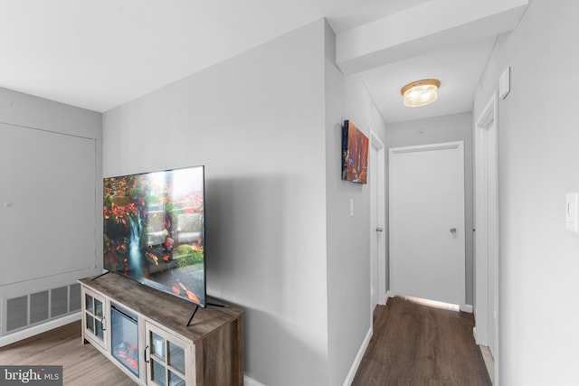hallway with visible vents, baseboards, and wood finished floors