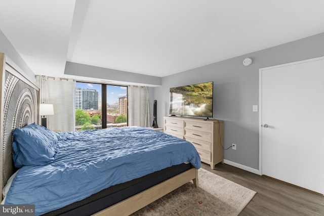 bedroom with baseboards and wood finished floors