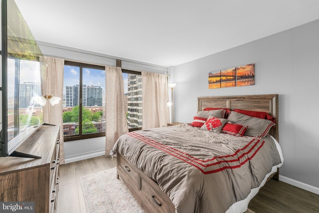 bedroom featuring baseboards and wood finished floors