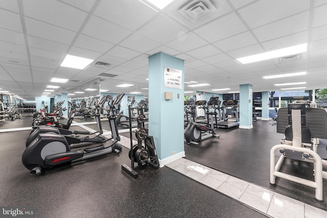 gym featuring baseboards, a drop ceiling, and visible vents