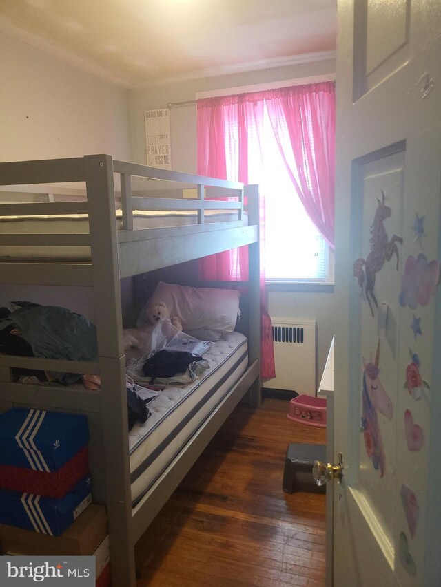 bedroom featuring radiator and wood finished floors