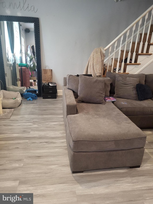 living area with wood finished floors and stairway