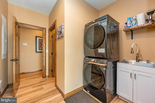 17 Green Jacket Ct, Mc Henry, MD 21541 - clothes washing area featuring stacked washer and dryer, cabinet space, light wood finished floors, a sink, and baseboards