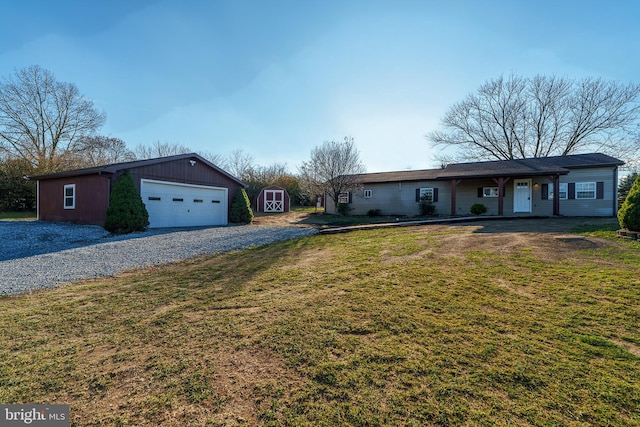 single story home featuring a shed, an outbuilding, a front yard, a garage, and gravel driveway