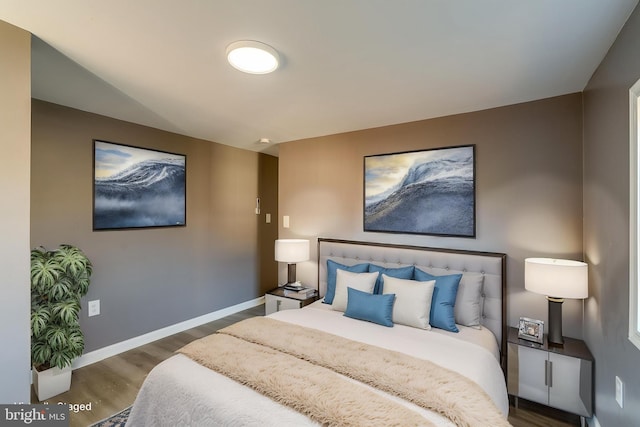 bedroom with baseboards and wood finished floors