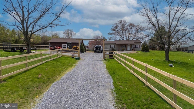 view of front of house with fence, a front lawn, and driveway