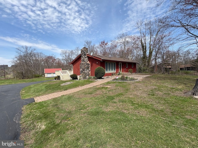 711 Clymer Ave, Sellersville, PA 18960 - view of property exterior featuring a garage, a chimney, and a lawn