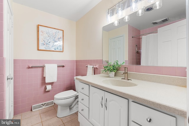 711 Clymer Ave, Sellersville, PA 18960 - bathroom featuring tile patterned floors, toilet, vanity, tile walls, and wainscoting