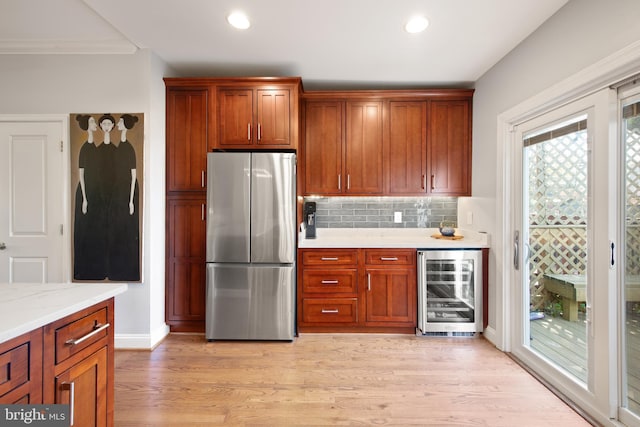 728 Farragut St NW, Washington, DC 20011 - kitchen with brown cabinets, light wood-style floors, freestanding refrigerator, decorative backsplash, and wine cooler