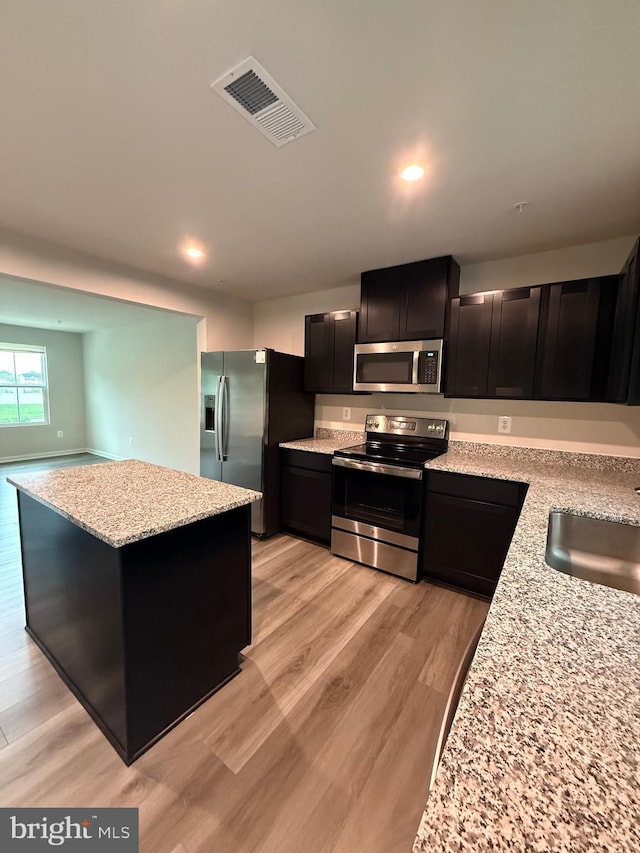 506 Red Bill Ln, Cambridge, MD 21613 - kitchen featuring a sink, appliances with stainless steel finishes, visible vents, a kitchen island, and light stone countertops