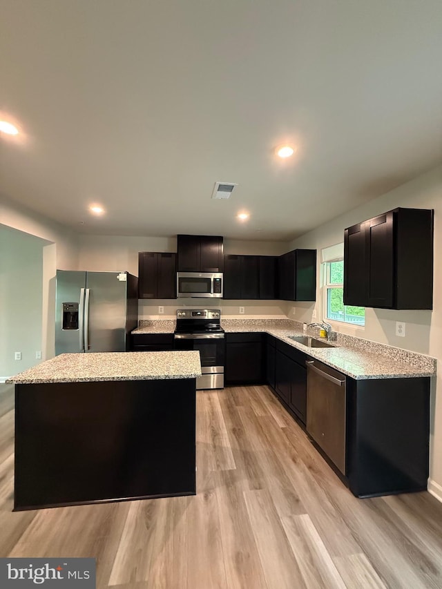 506 Red Bill Ln, Cambridge, MD 21613 - kitchen with light stone counters, a sink, visible vents, stainless steel appliances, and light wood-type flooring