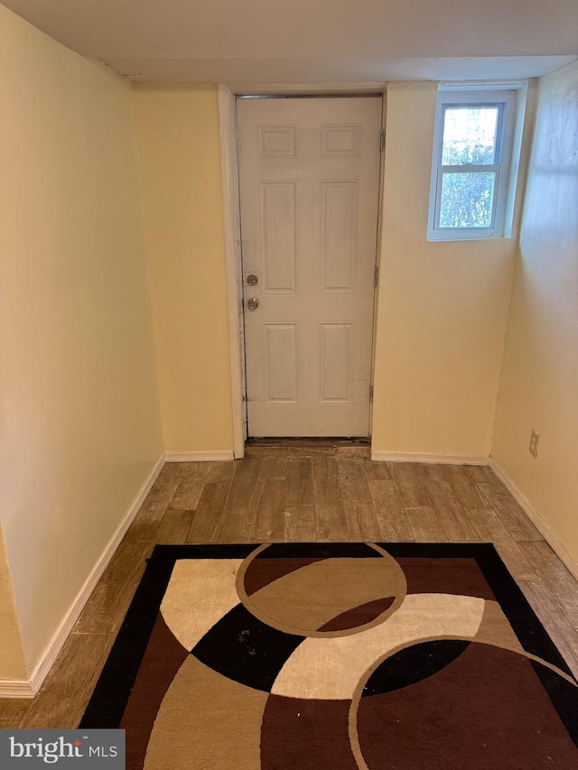foyer entrance with baseboards and wood finished floors