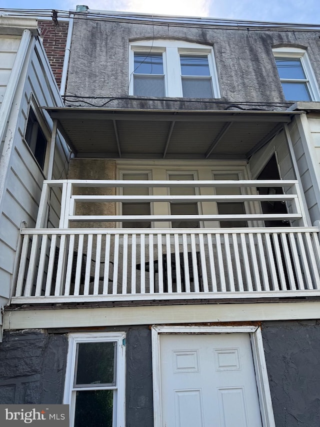 exterior space with stucco siding and a balcony