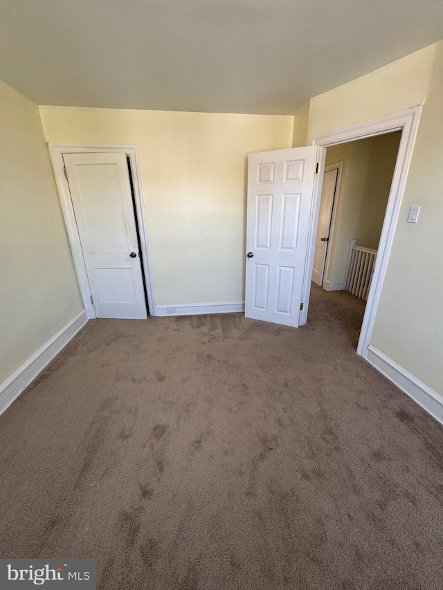 unfurnished bedroom featuring baseboards and carpet
