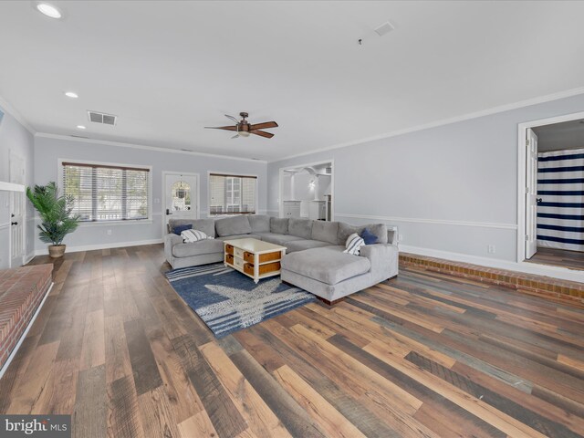 living area featuring crown molding, visible vents, ceiling fan, baseboards, and wood finished floors