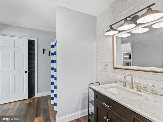 bathroom with baseboards, wood finished floors, vanity, and a shower with shower curtain