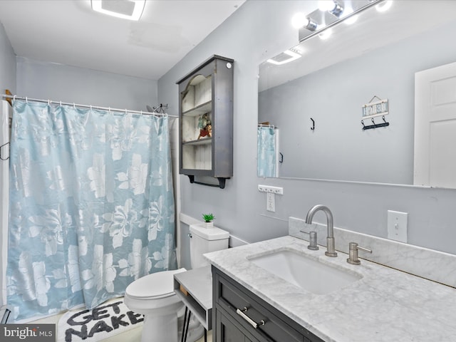full bathroom featuring toilet, vanity, and a shower with curtain