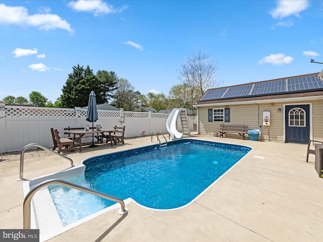 view of pool featuring a fenced in pool, a fenced backyard, a water slide, a patio area, and outdoor dining area