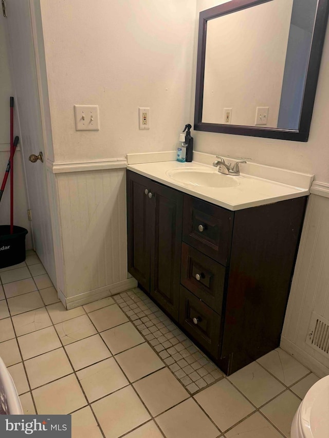 3322 Windermere Dr, Bushkill, PA 18324 - bathroom featuring a wainscoted wall, tile patterned floors, toilet, vanity, and a decorative wall