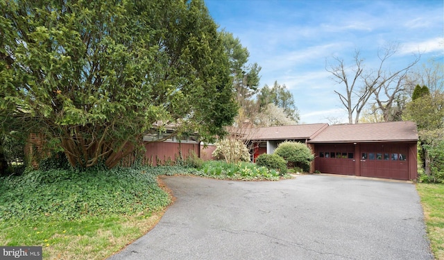 ranch-style house with aphalt driveway and an attached garage