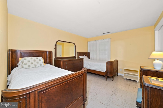 bedroom featuring baseboards and visible vents