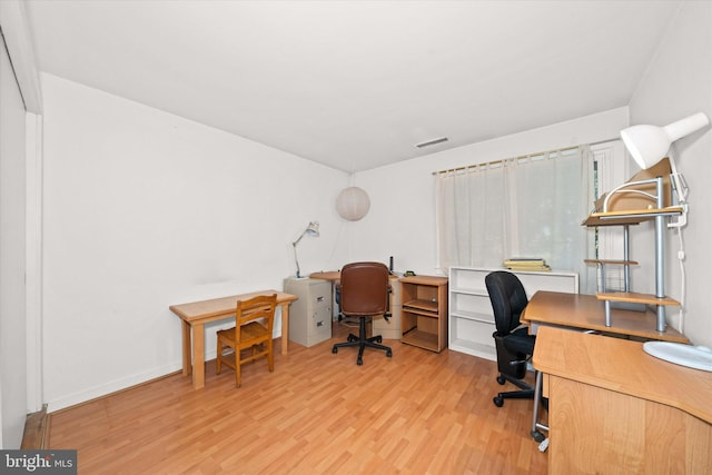 home office featuring visible vents and wood finished floors