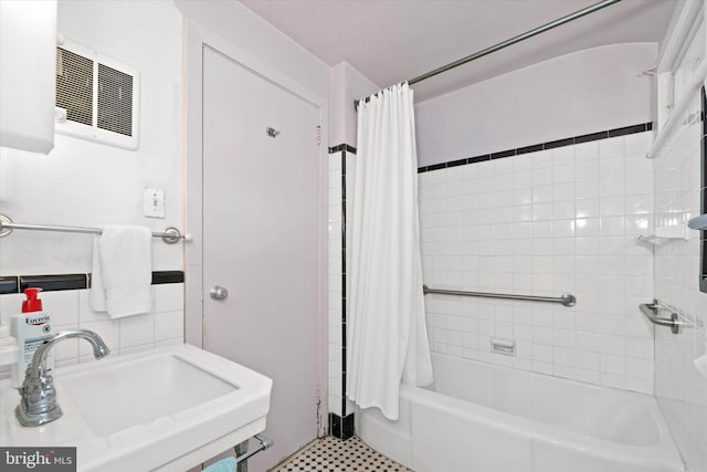 bathroom featuring a sink, visible vents, and shower / bath combination with curtain