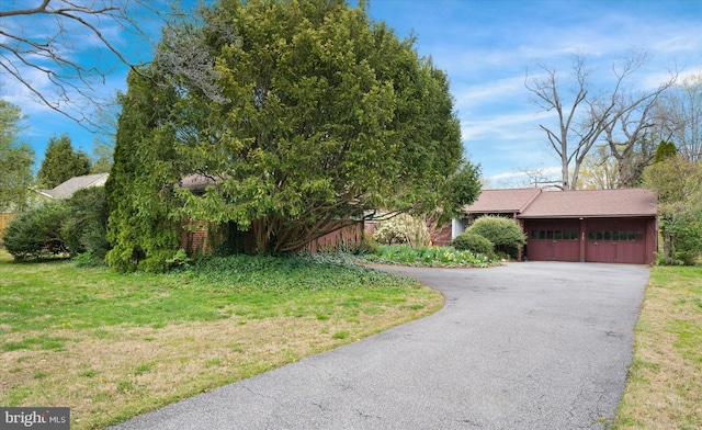 view of front facade with a front yard, an attached garage, and driveway