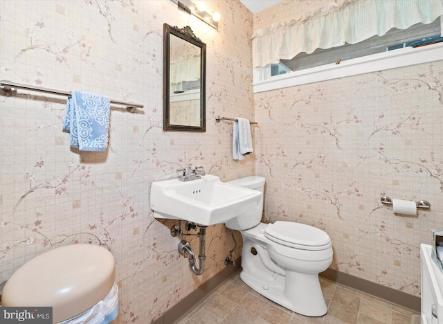 bathroom featuring a sink, tile patterned flooring, toilet, and baseboards
