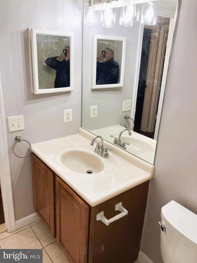 bathroom featuring vanity, tile patterned floors, toilet, and baseboards