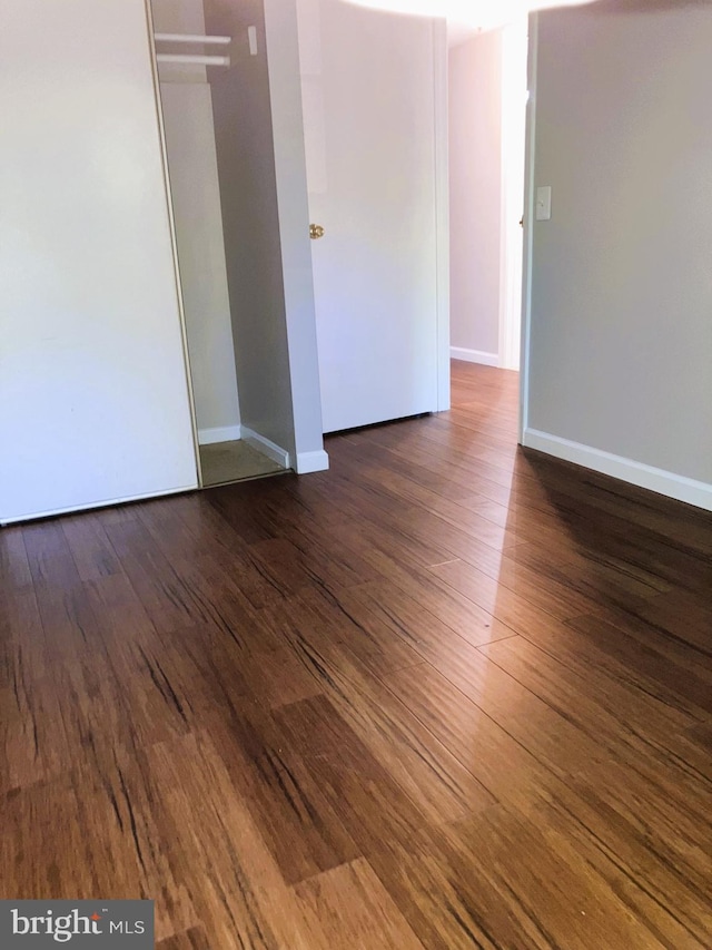 unfurnished room with wood finished floors and baseboards