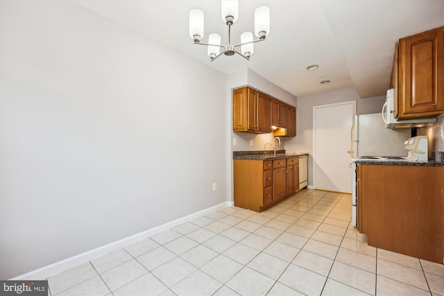 kitchen with a chandelier, baseboards, brown cabinets, a sink, and light tile patterned flooring