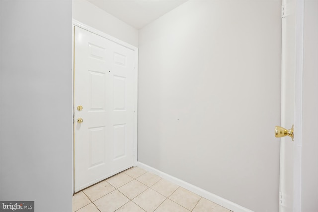 entryway with light tile patterned flooring and baseboards