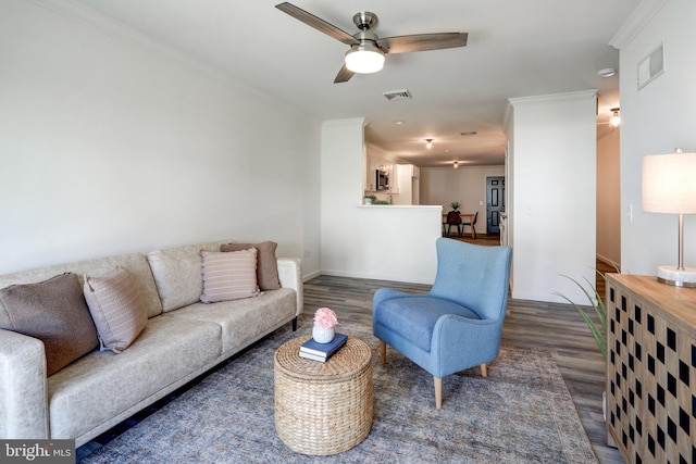 living room featuring ceiling fan, ornamental molding, wood finished floors, and visible vents