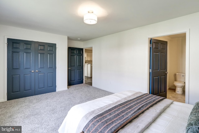 carpeted bedroom with baseboards, ensuite bath, and a closet