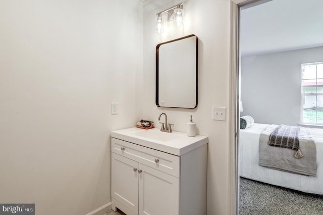 bathroom featuring baseboards, ensuite bath, and vanity