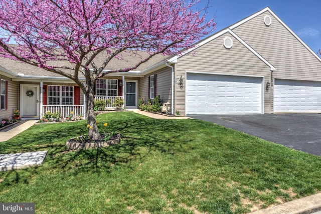 single story home with driveway, covered porch, a front yard, and a garage