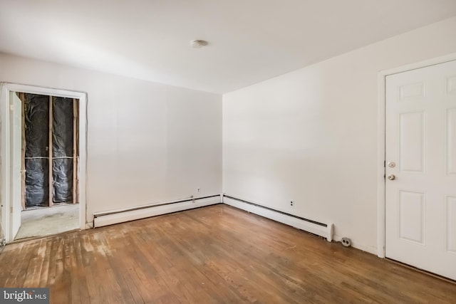 spare room featuring a baseboard heating unit, wood finished floors, and baseboard heating