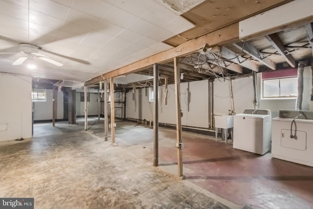 below grade area featuring ceiling fan, a sink, and washer and clothes dryer