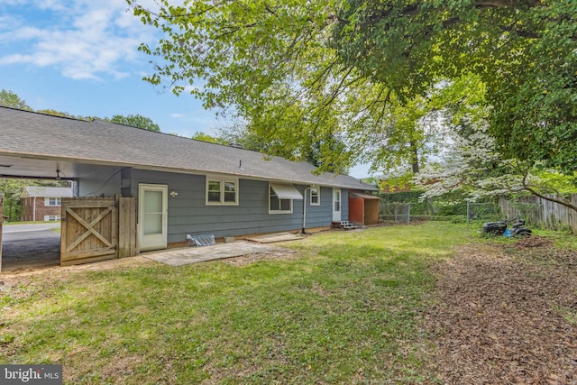 rear view of house with a yard, a patio, and fence
