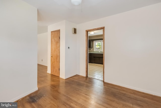 unfurnished room featuring wood finished floors, baseboards, and ceiling fan