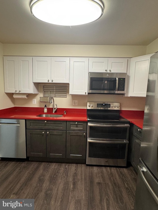803 N Howard St Unit 435, Alexandria, VA 22304 - kitchen with appliances with stainless steel finishes, a sink, dark wood-style floors, and white cabinetry