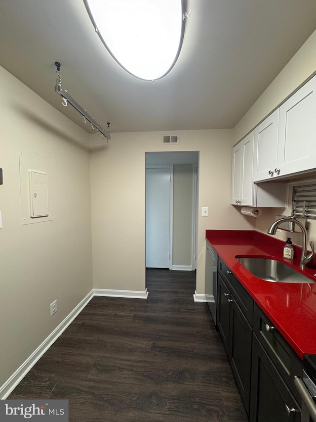 803 N Howard St Unit 435, Alexandria, VA 22304 - kitchen featuring a sink, stainless steel dishwasher, white cabinetry, dark countertops, and dark wood-style floors