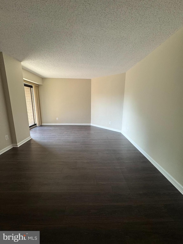 803 N Howard St Unit 435, Alexandria, VA 22304 - spare room featuring dark wood-style flooring, a textured ceiling, and baseboards