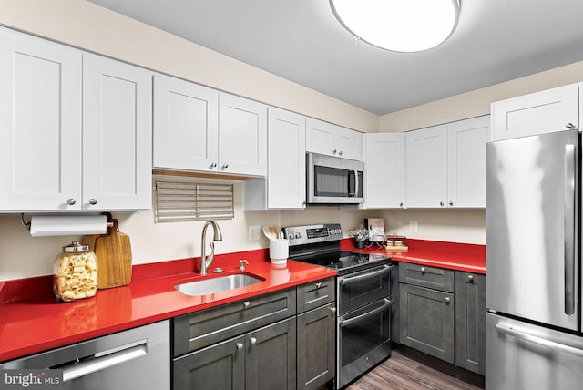 803 N Howard St Unit 435, Alexandria, VA 22304 - kitchen featuring appliances with stainless steel finishes, a sink, dark wood-style floors, white cabinets, and light countertops