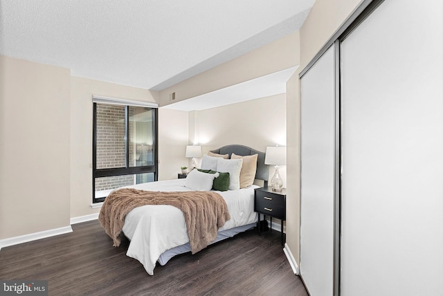 803 N Howard St Unit 435, Alexandria, VA 22304 - bedroom with dark wood-style flooring, baseboards, and a closet