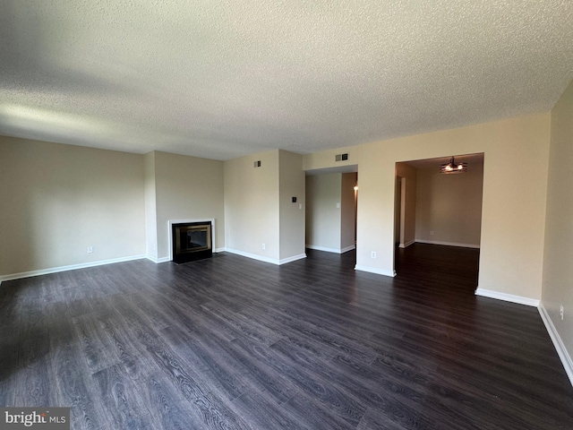 803 N Howard St Unit 435, Alexandria, VA 22304 - unfurnished living room with a textured ceiling, dark wood-style flooring, a glass covered fireplace, and baseboards