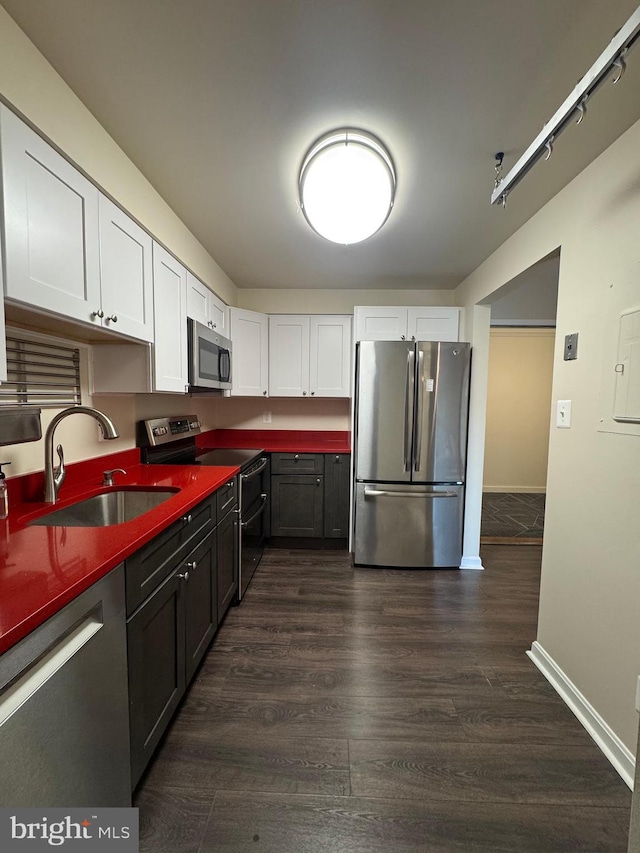 803 N Howard St Unit 435, Alexandria, VA 22304 - kitchen with appliances with stainless steel finishes, a sink, white cabinets, dark wood finished floors, and baseboards