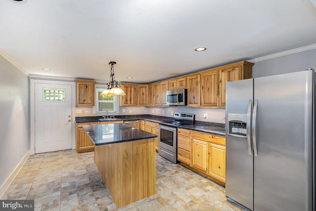 kitchen with baseboards, ornamental molding, a kitchen island, and stainless steel appliances