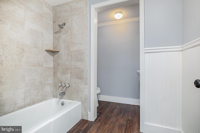 full bath featuring bathing tub / shower combination, toilet, and wood finished floors